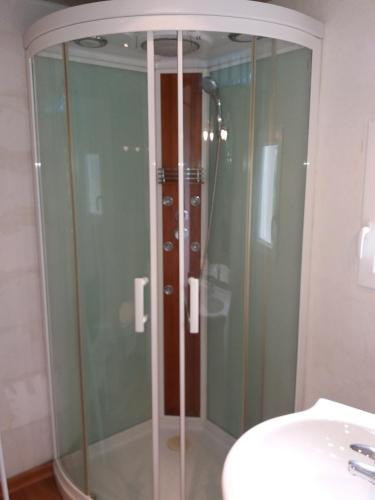 a glass shower in a bathroom next to a sink at Apartment Albert parking privé gratuit in Limoux