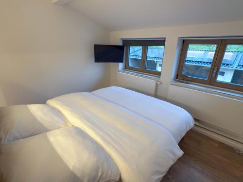a bedroom with two white beds and two windows at Landhaus Jarnitz in Ralswiek