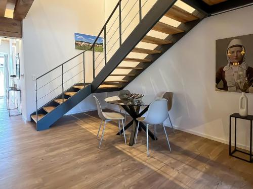 a dining room with a table and a staircase at Landhaus Jarnitz in Ralswiek