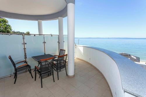 a balcony with a table and chairs and the ocean at Sunset Split Rooms in Podstrana