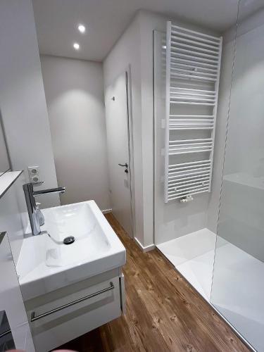 a bathroom with a white sink and a shower at Landhaus Jarnitz in Ralswiek