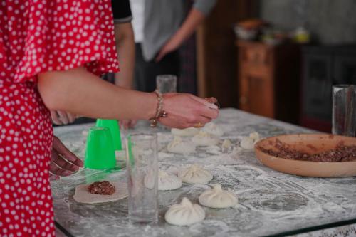 a woman in a red dress making food on a table at Winery Matisi in Babaneuri