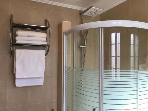a bathroom with a shower with towels and a glass at GuestReady - Volcanic Nature- Sea and Tranquillity in Mosteiros