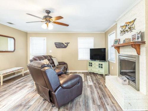 a living room with a leather couch and a fireplace at Toes in the Sand in Tybee Island