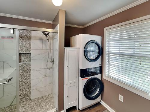 a bathroom with a shower and a washer and dryer at Toes in the Sand in Tybee Island