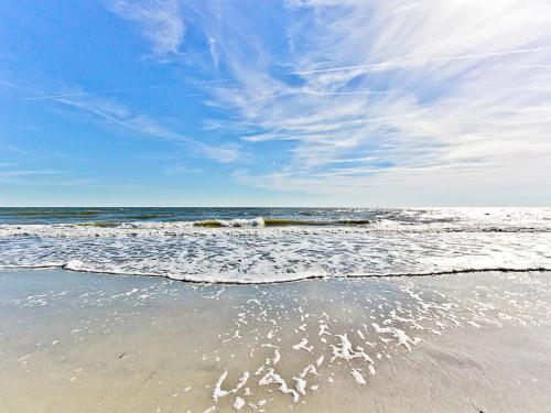 a sandy beach with waves on the ocean at Toes in the Sand in Tybee Island