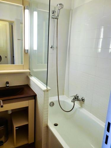 une salle de bain avec une baignoire, un lavabo et une douche dans l'établissement Résidence Les Parcs de Grimaud - maeva Home - Studio vue mer 4 personnes - Sélection MAE-3243, à Grimaud
