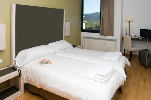 a bedroom with a large bed and a large window at Hospedium Hotel Convento de Santa Ana in Atienza