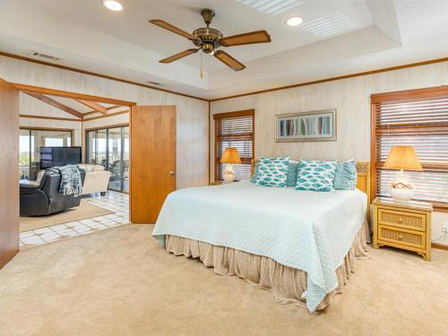 a bedroom with a bed and a ceiling fan at Sea Gull Ocean Villa in Tybee Island