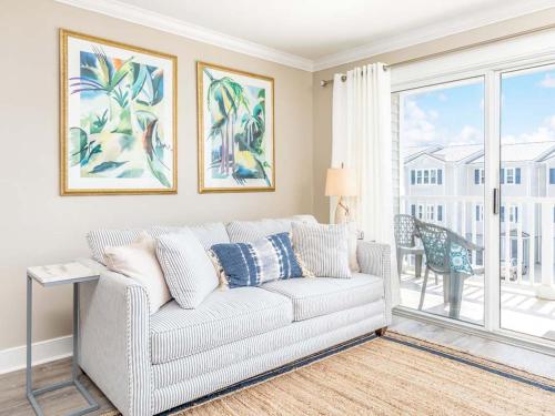 a living room with a couch and a large window at Summer Winds 528 in Tybee Island