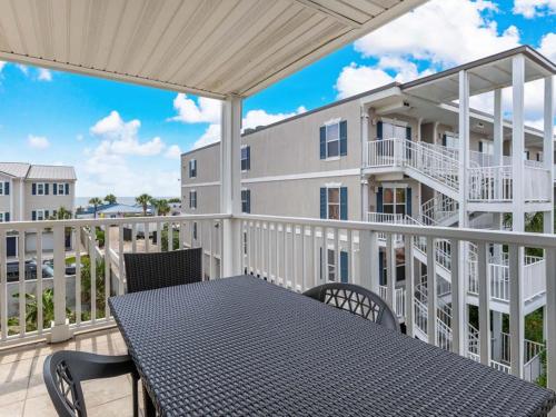 a balcony with a table and chairs and a building at Summer Winds 528 in Tybee Island