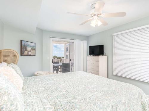 a bedroom with a bed and a ceiling fan at Summer Winds 528 in Tybee Island