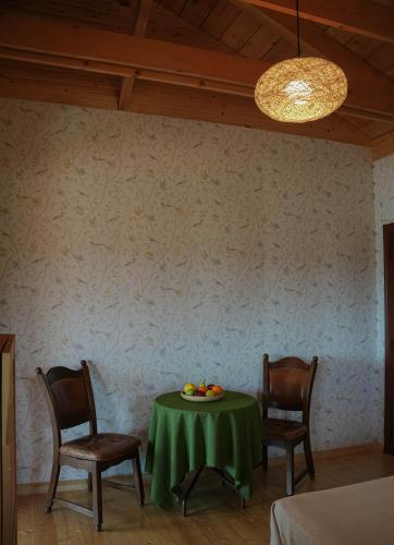 a dining room with a green table and two chairs at Winery Matisi in Babaneuri