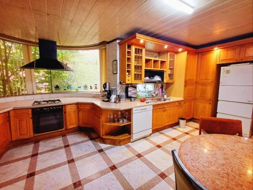 a kitchen with wooden cabinets and a large window at The Red Brick Grove in Wonju