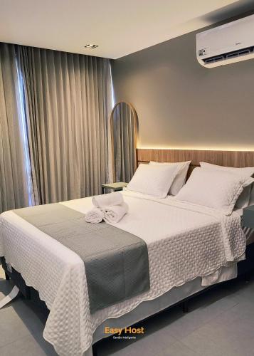 a bedroom with a large bed with white sheets at Simple Smart Residence - By EasyHost in Tambaú