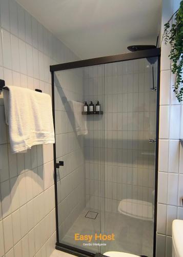 a shower with a glass door in a bathroom at Simple Smart Residence - By EasyHost in Tambaú