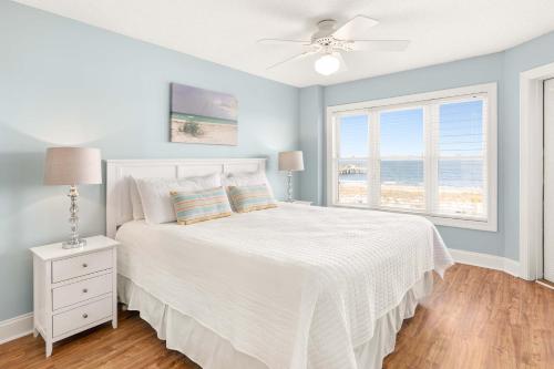 a bedroom with a white bed and a window at Sandpiper 302 in Tybee Island