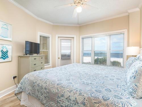 une chambre avec un lit, une télévision et des fenêtres dans l'établissement Sandpiper 205, à Tybee Island