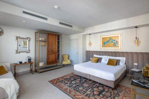 a bedroom with two beds and a table and a mirror at Hotel Villa Paradiso in Taormina