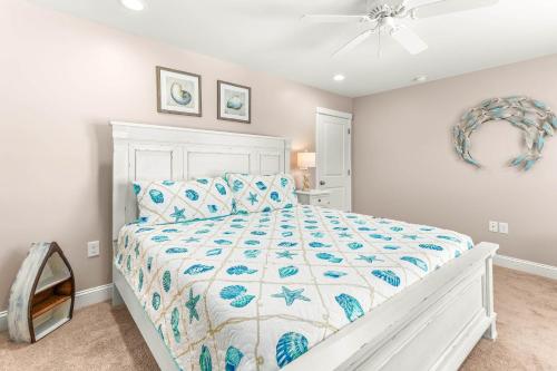 a bedroom with a white bed and a ceiling fan at Peach Coral in Tybee Island