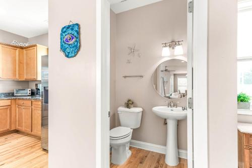 a bathroom with a toilet and a sink at Peach Coral in Tybee Island