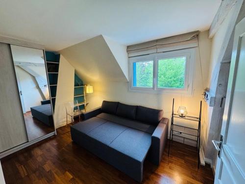 un salon avec un canapé et une fenêtre dans l'établissement Villa close to Le Mans 24h with Swimming pool and parking, à La Celle-sous-Gouzon