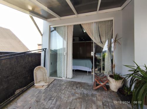 a balcony of a house with a bedroom at Quartos familiares com piscina in Encantado