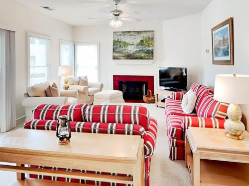 a living room with red and white striped couches at Mercy Me in Tybee Island