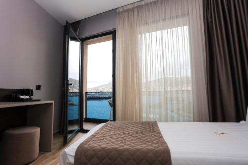 a hotel room with a bed and a large window at Joelle Premium Hotel in Sarandë