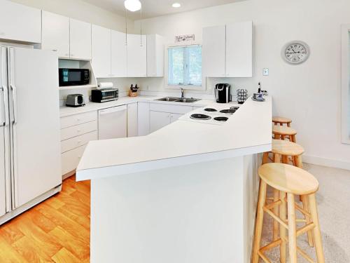 a kitchen with white cabinets and a white counter top at Mercy Me in Tybee Island