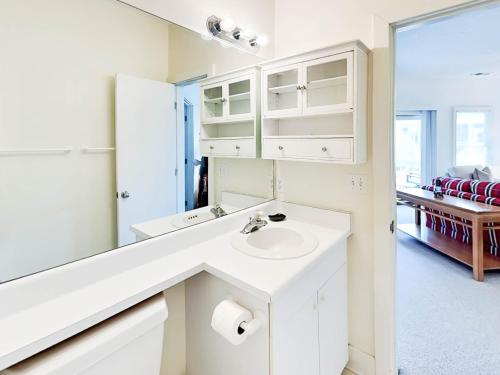 a white bathroom with a sink and a mirror at Mercy Me in Tybee Island