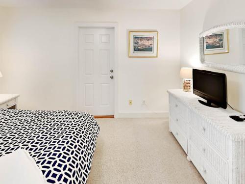 a bedroom with a bed and a tv on a dresser at Mercy Me in Tybee Island