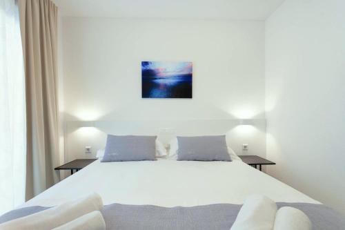 a bedroom with a large white bed with two tables at Sunset Split Rooms in Podstrana
