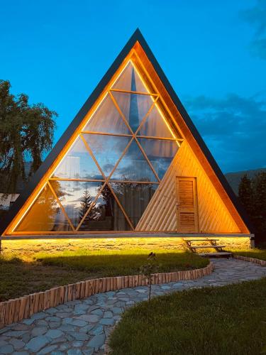 a pyramid shaped building with a large window at Bujtina Fati Art in Ersekë