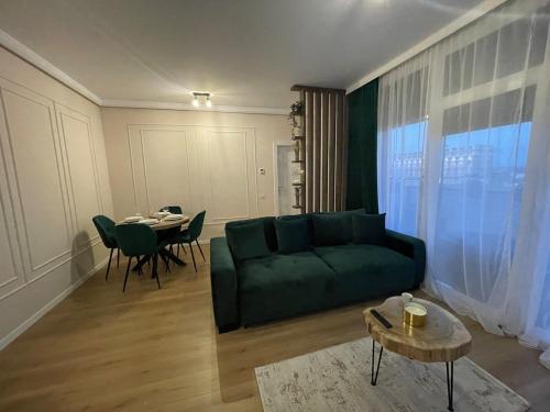 a living room with a green couch and a table at Apartament Central Arad AFI 2 camere Ared in Arad