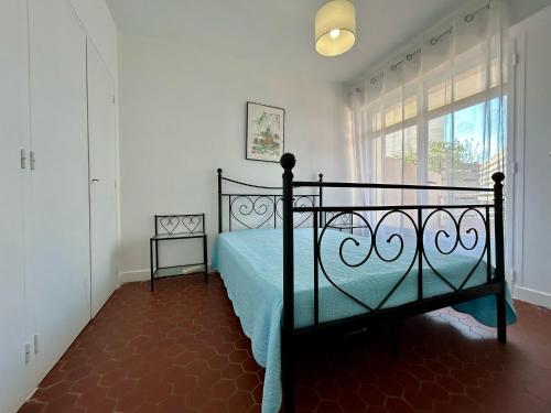 - une chambre avec un lit doté d'un couvre-lit bleu et d'une fenêtre dans l'établissement ST CYPRIEN PORT APPARTEMENT T3 TERRASSE -PARKING 50 M des PLAGES, à Saint Cyprien Plage