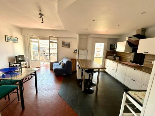 une cuisine et un salon avec une table et un canapé dans l'établissement ST CYPRIEN PORT APPARTEMENT T3 TERRASSE -PARKING 50 M des PLAGES, à Saint Cyprien Plage