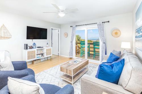 a living room with a couch and a tv at Lighthouse Point 25A in Tybee Island