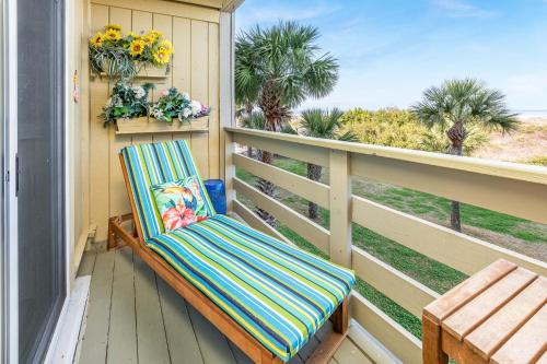 a balcony with a chair and a view of the ocean at Lighthouse Point 25A in Tybee Island