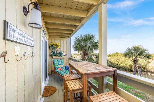 a porch with a table and chairs and a view of the beach at Lighthouse Point 25A in Tybee Island