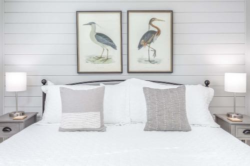 two framed prints of birds on the wall above a bed at Lighthouse Point 25A in Tybee Island