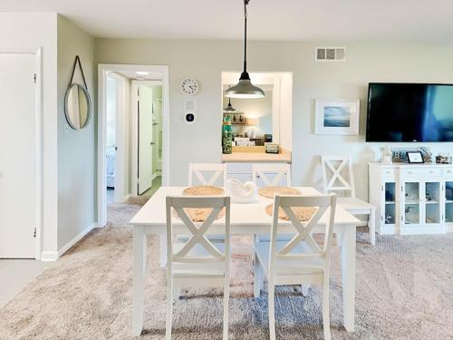 a white dining room with a white table and chairs at Lighthouse Point 15C in Tybee Island