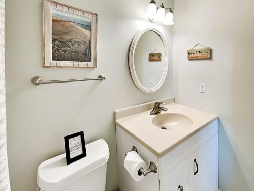 a bathroom with a sink and a toilet and a mirror at Lighthouse Point 15C in Tybee Island