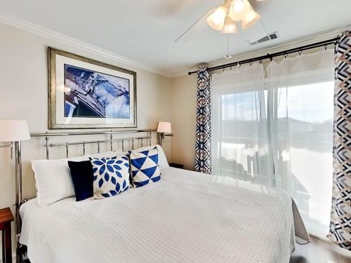 a bedroom with a white bed with blue and white pillows at Lighthouse Point 9C in Tybee Island