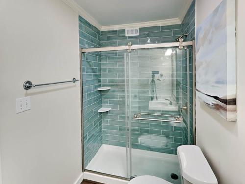 a bathroom with a shower with a toilet and a sink at Lighthouse Point 9C in Tybee Island
