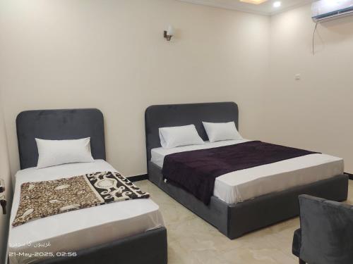 a bedroom with two beds and a bedskirts at Islamabad Grand Retreat in Islamabad
