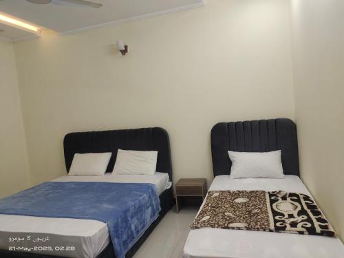 two beds sitting next to each other in a room at Islamabad Grand Retreat in Islamabad