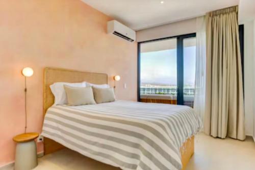 a bedroom with a large bed with a large window at Apartamento Luxury Nayarit vista al mar Mexico in Nuevo Vallarta 