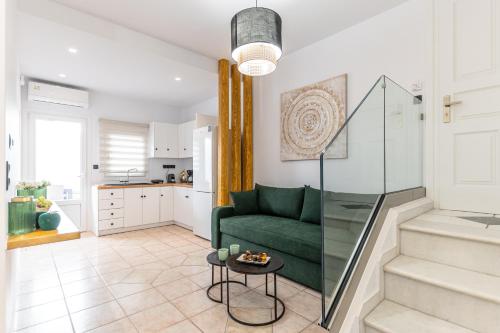 a living room with a green couch and a table at Golden Bay in Agios Prokopios