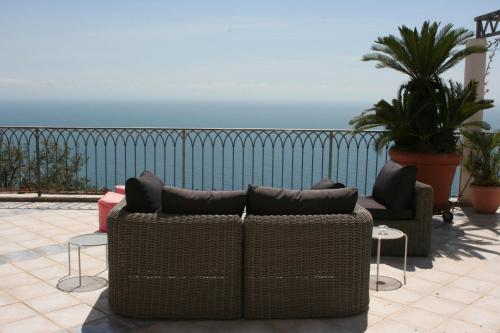 a couch and chairs on a patio with the ocean at b&b I Limoni in Ravello